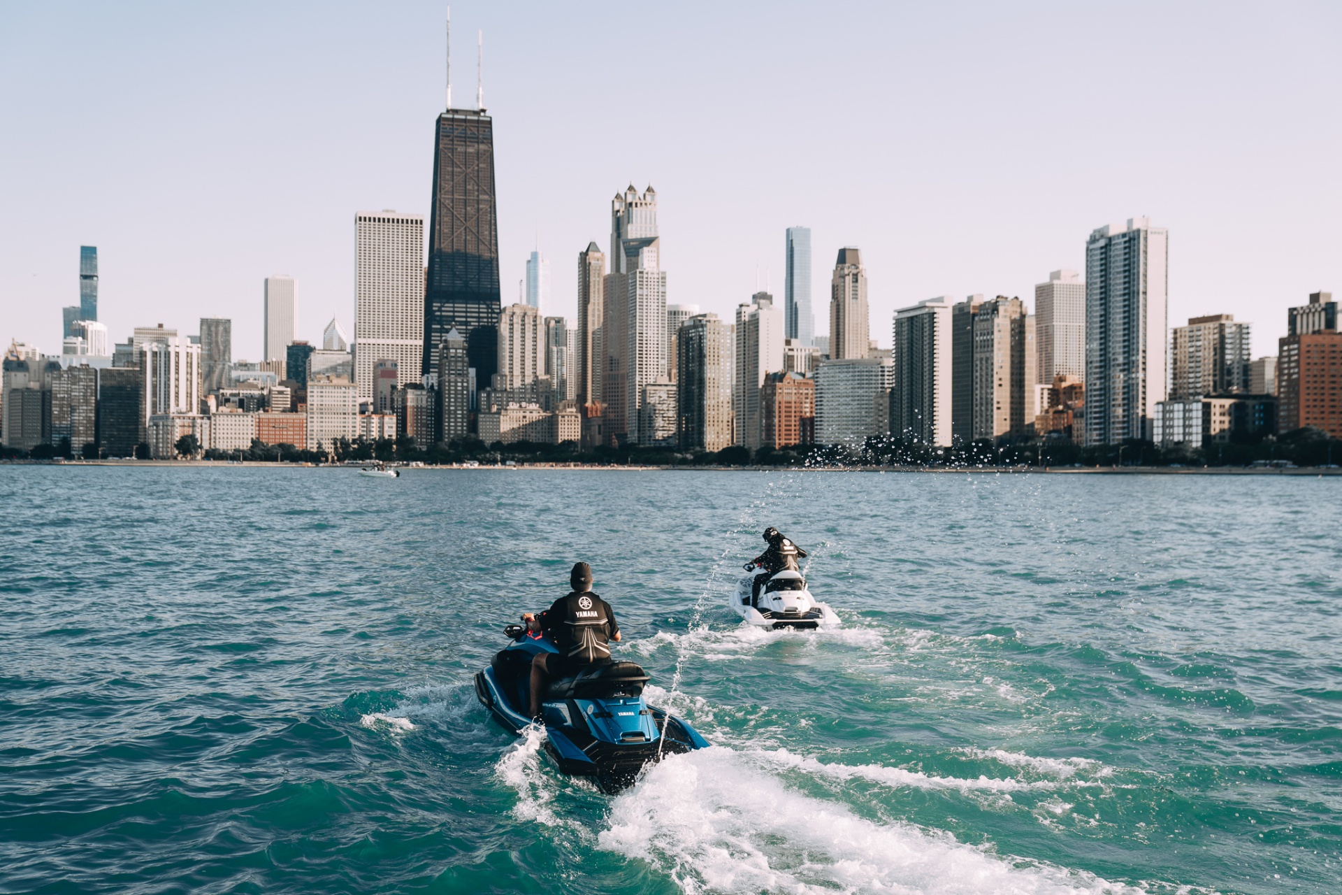 Two jet skis cruising toward the Chicago skyline