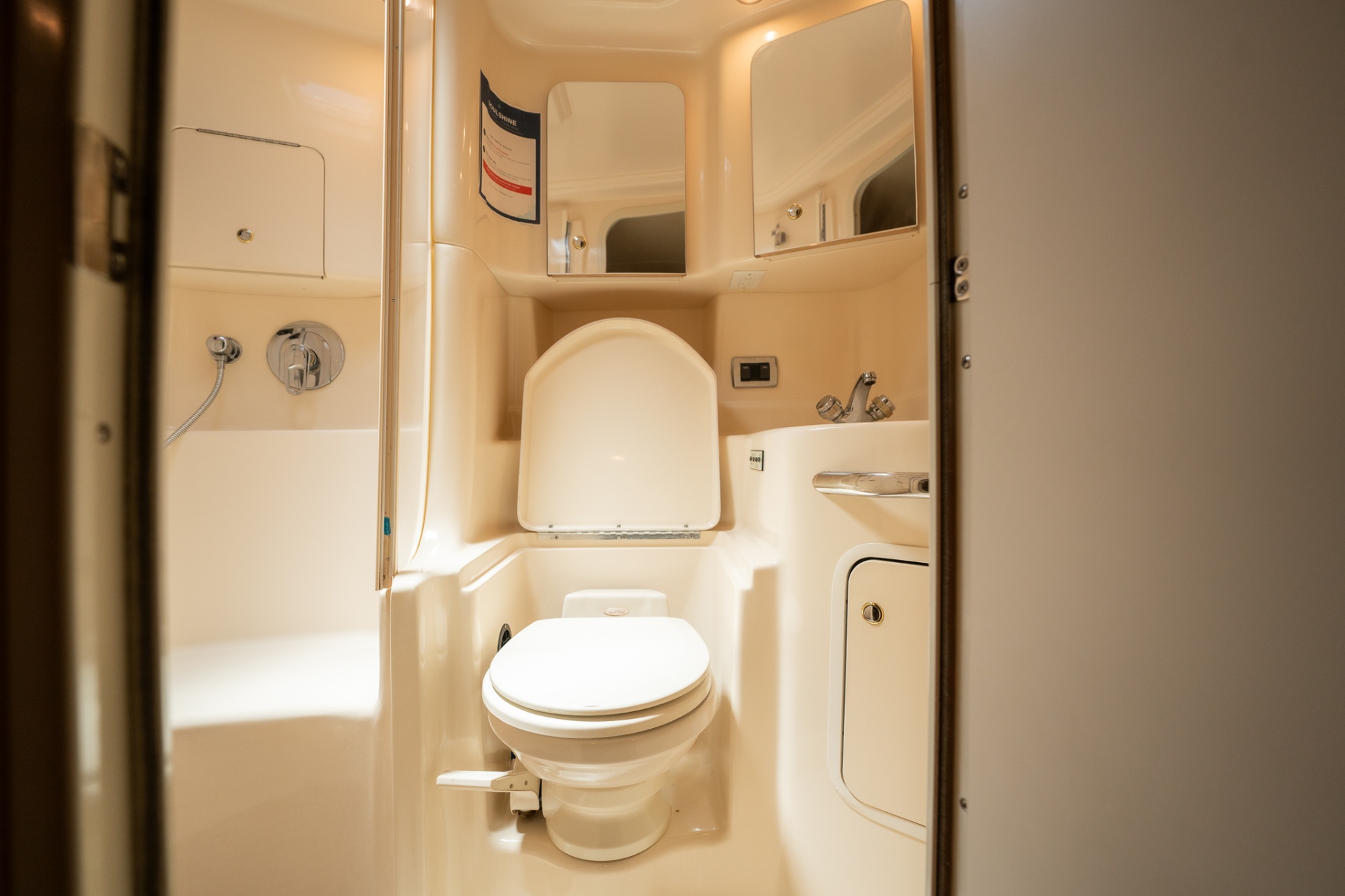 Enclosed head with toilet, shower, and mirrors