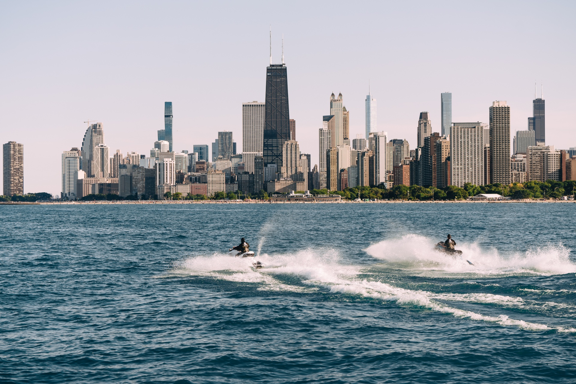 Pair of skis carving Lake Michigan with skyline behind